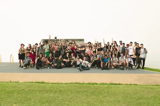 A joyful group of diverse friends celebrating outdoors on a sunny day.